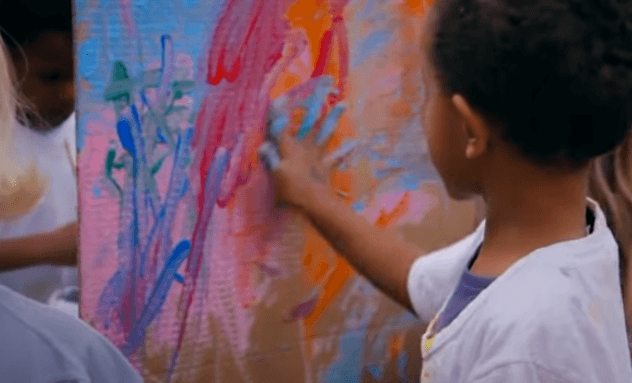 Crianças pintando mural coletivo