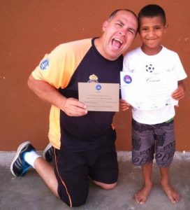 Gil Brasil e criança no Instituto Atleta Bom de Nota.