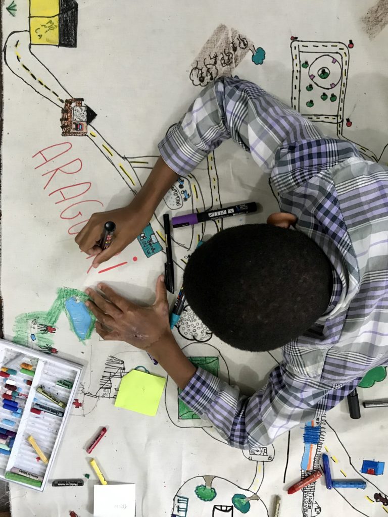Estudante desenhando e escrevendo o mapa de seu território